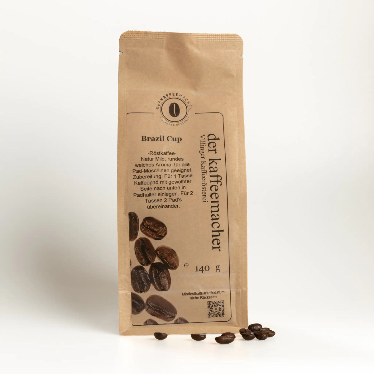 140 g Kaffeepackung aus braunem Kraftpapier mit Kaffeebohnen im Vordergrund von Der Kaffeemacher.
140 g coffee package made of brown kraft paper wirh Coffeebeans from Der Kaffeemacher.