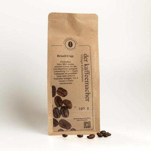140 g Kaffeepackung aus braunem Kraftpapier mit Kaffeebohnen im Vordergrund von Der Kaffeemacher.
140 g coffee package made of brown kraft paper wirh Coffeebeans from Der Kaffeemacher.